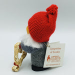 Swedish tomte girl with face mask holding straw heart