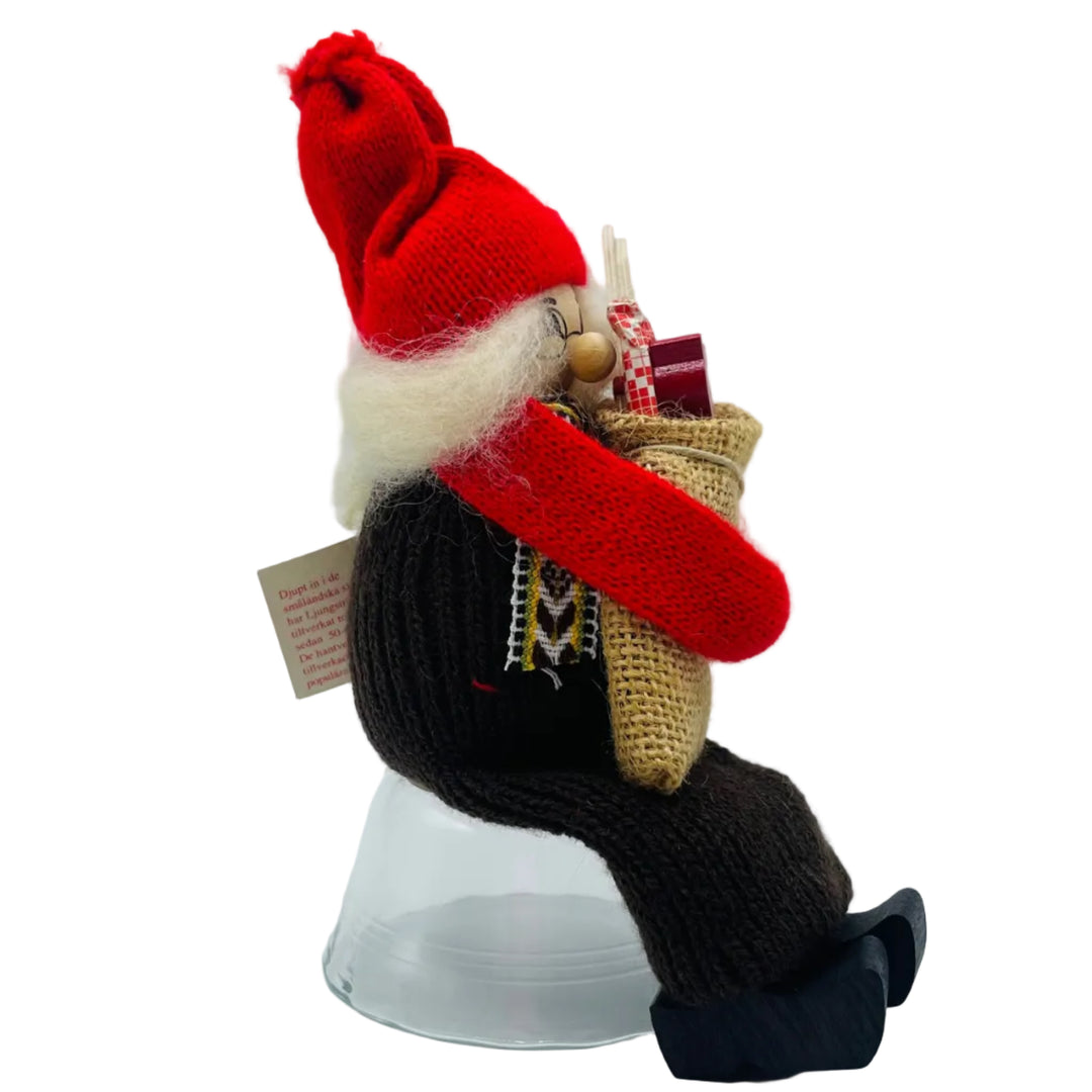Swedish tomte lady sitting holding a sack of gifts