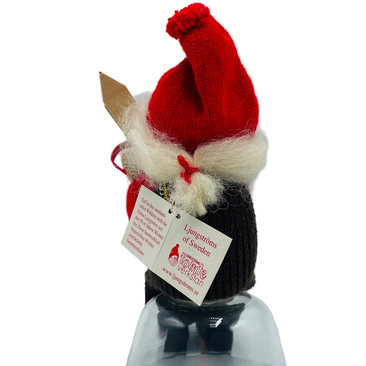 Swedish tomte lady sitting holding a sack of gifts