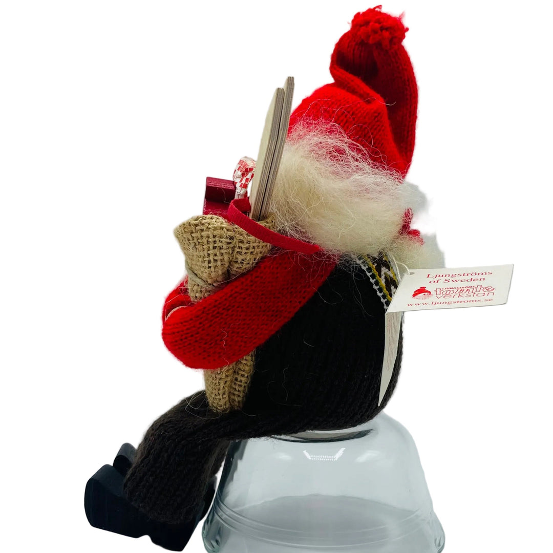 Swedish tomte lady sitting holding a sack of gifts