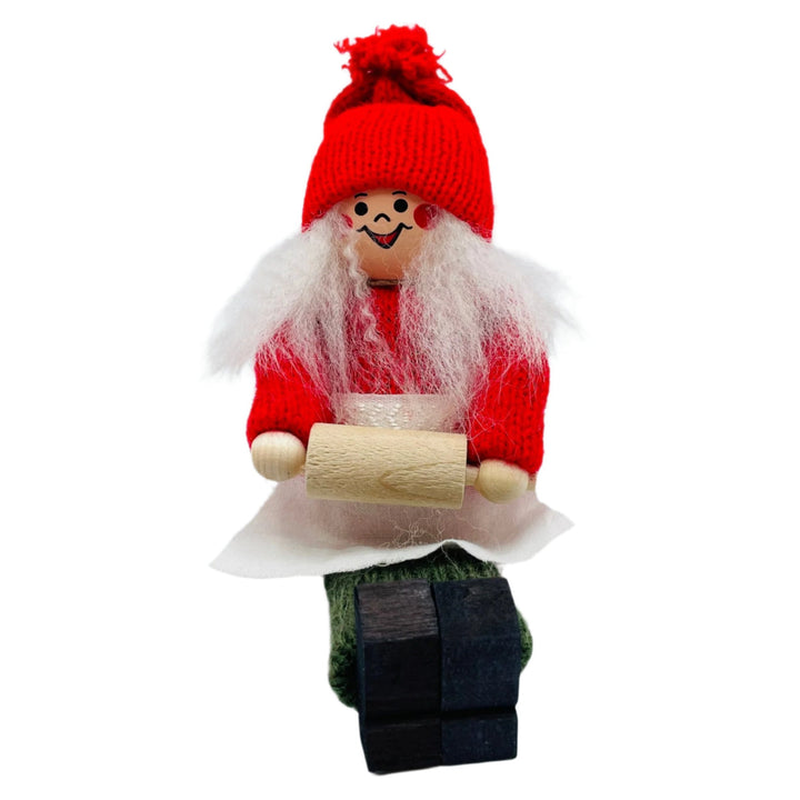 Swedish tomte lady sitting holding rolling pin