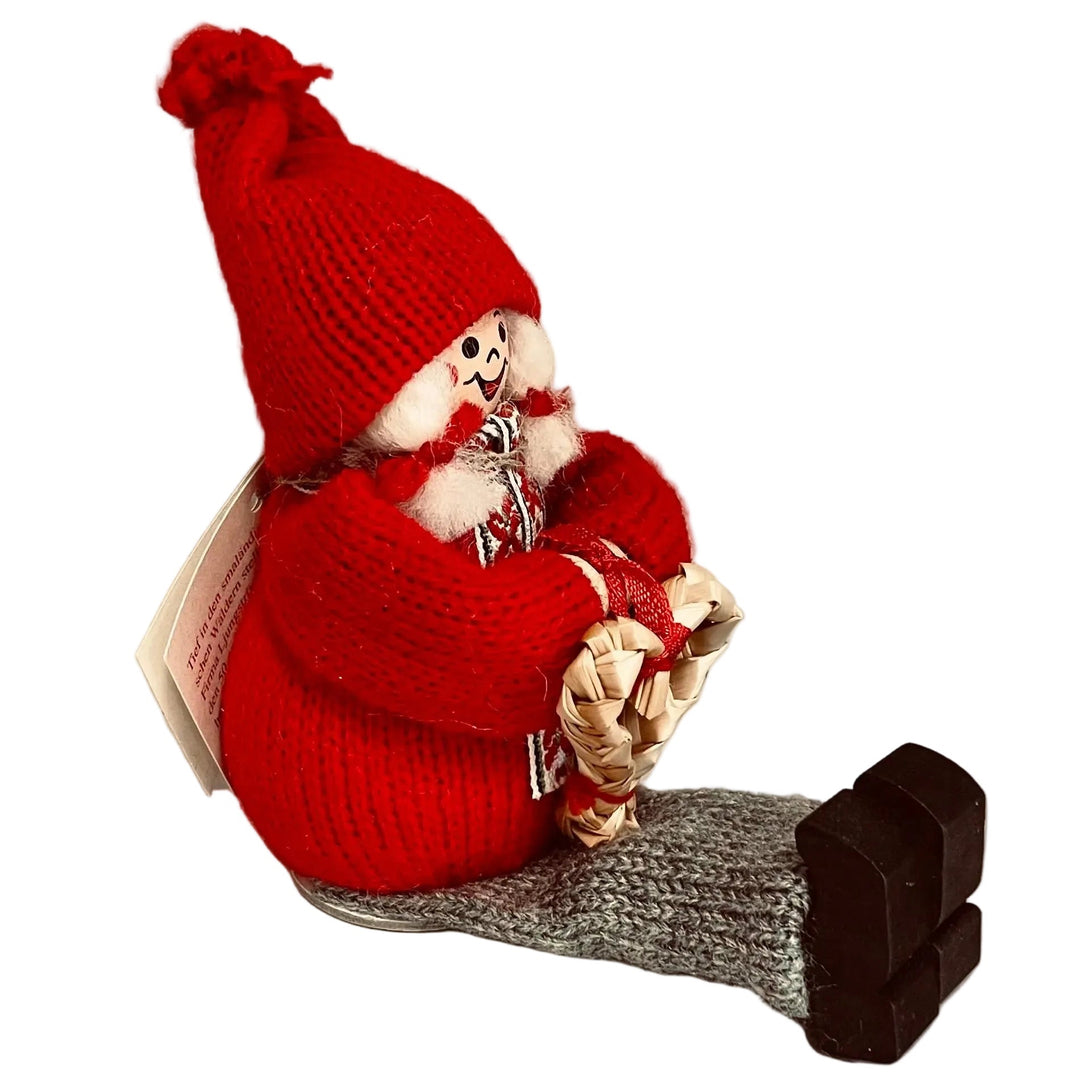 Swedish tomte lady sitting with straw heart