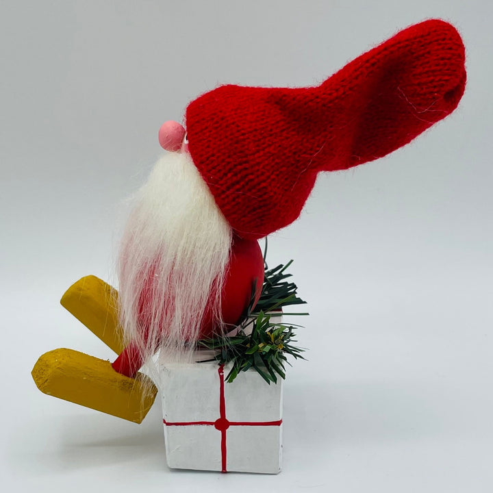 Hand made tomte sitting on gift