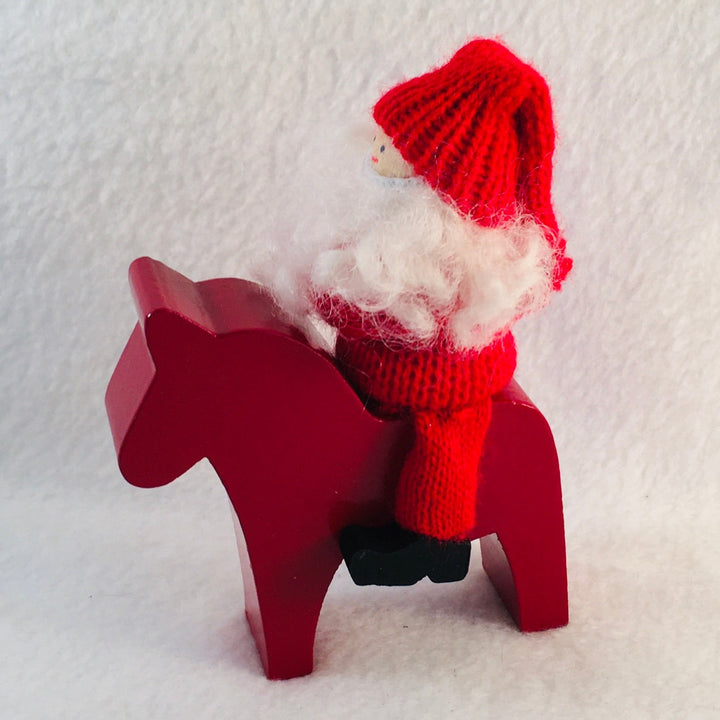 Swedish tomte riding a Dala horse