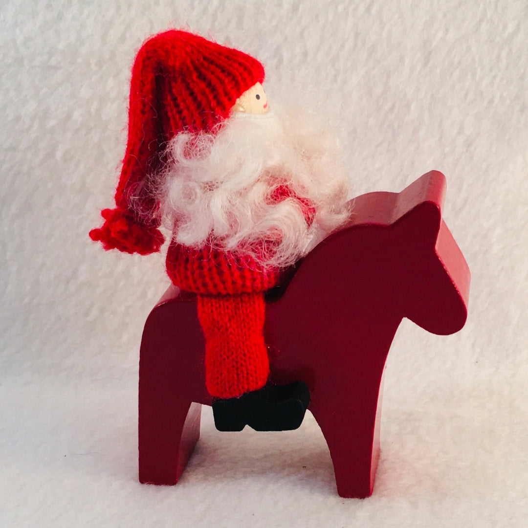 Swedish tomte riding a Dala horse