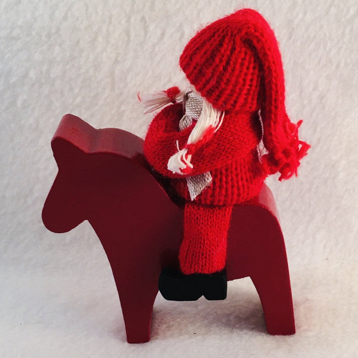 Swedish tomte riding a Dala horse