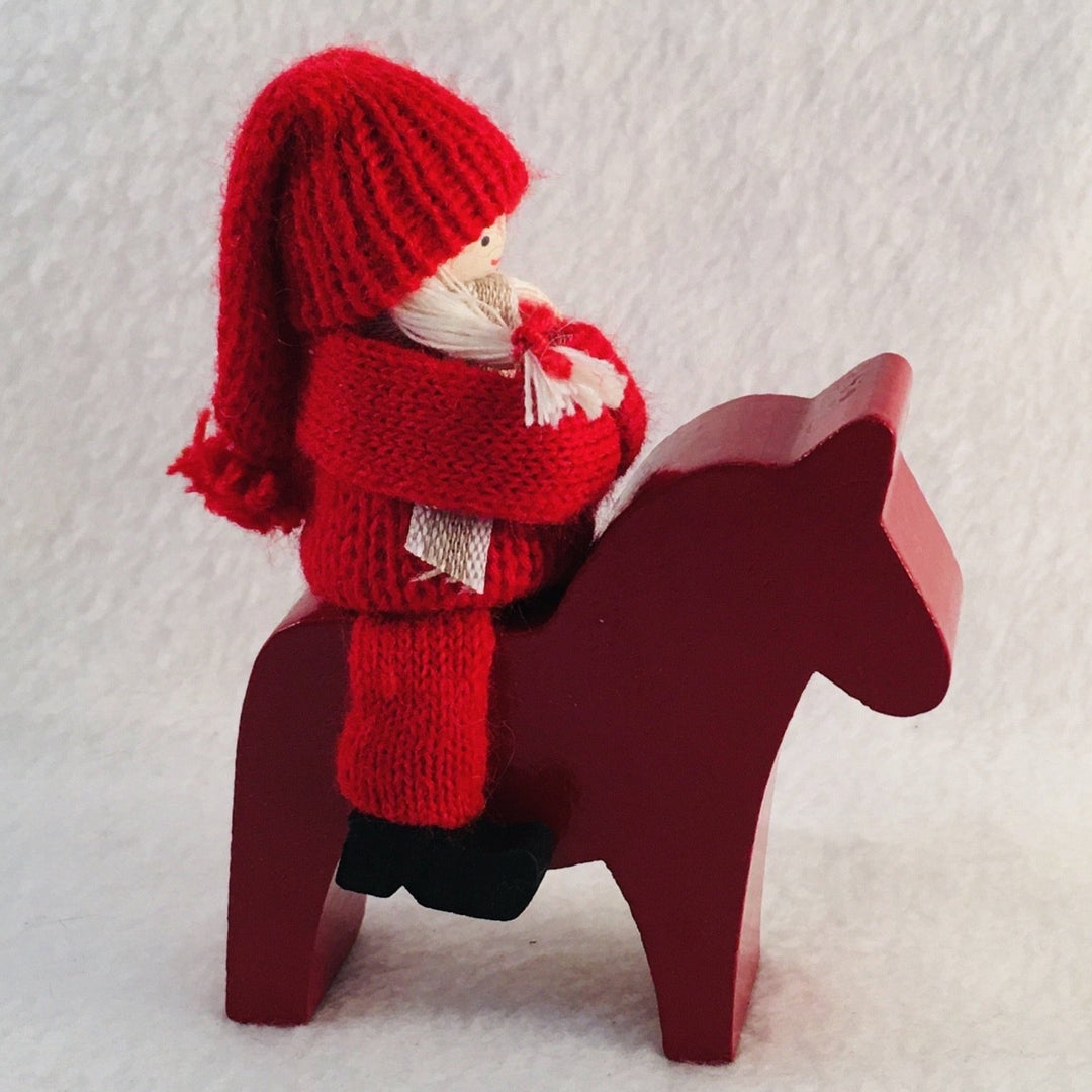 Swedish tomte riding a Dala horse