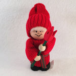 Swedish tomte holding a red tulip