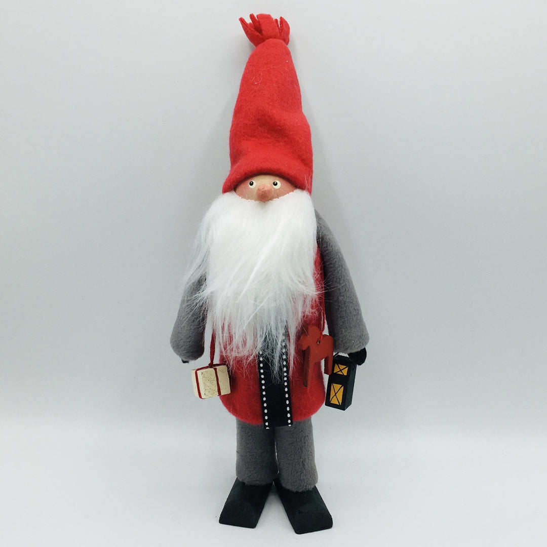 Hand made tomte holding a Dala horse, lantern & gift