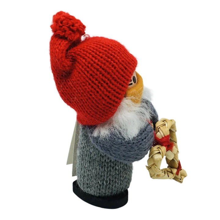 Swedish tomte girl with face mask holding straw heart