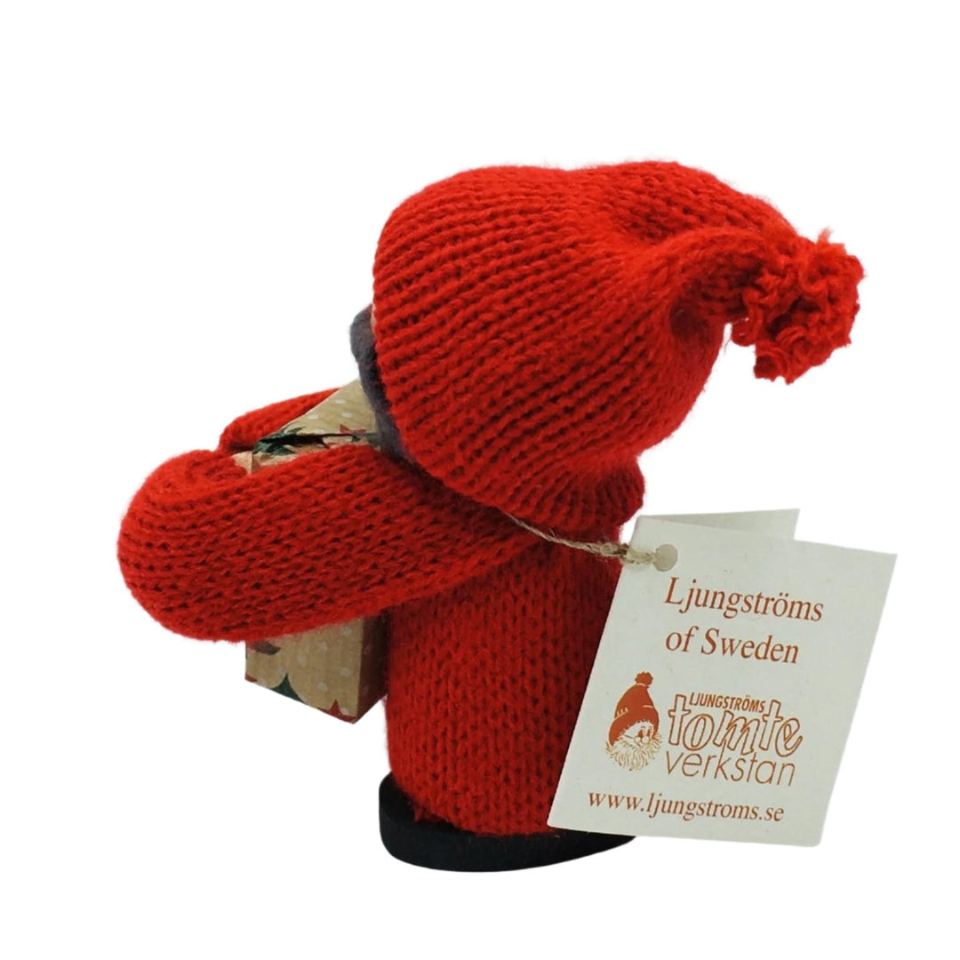 Swedish tomte boy with face mask holding gift