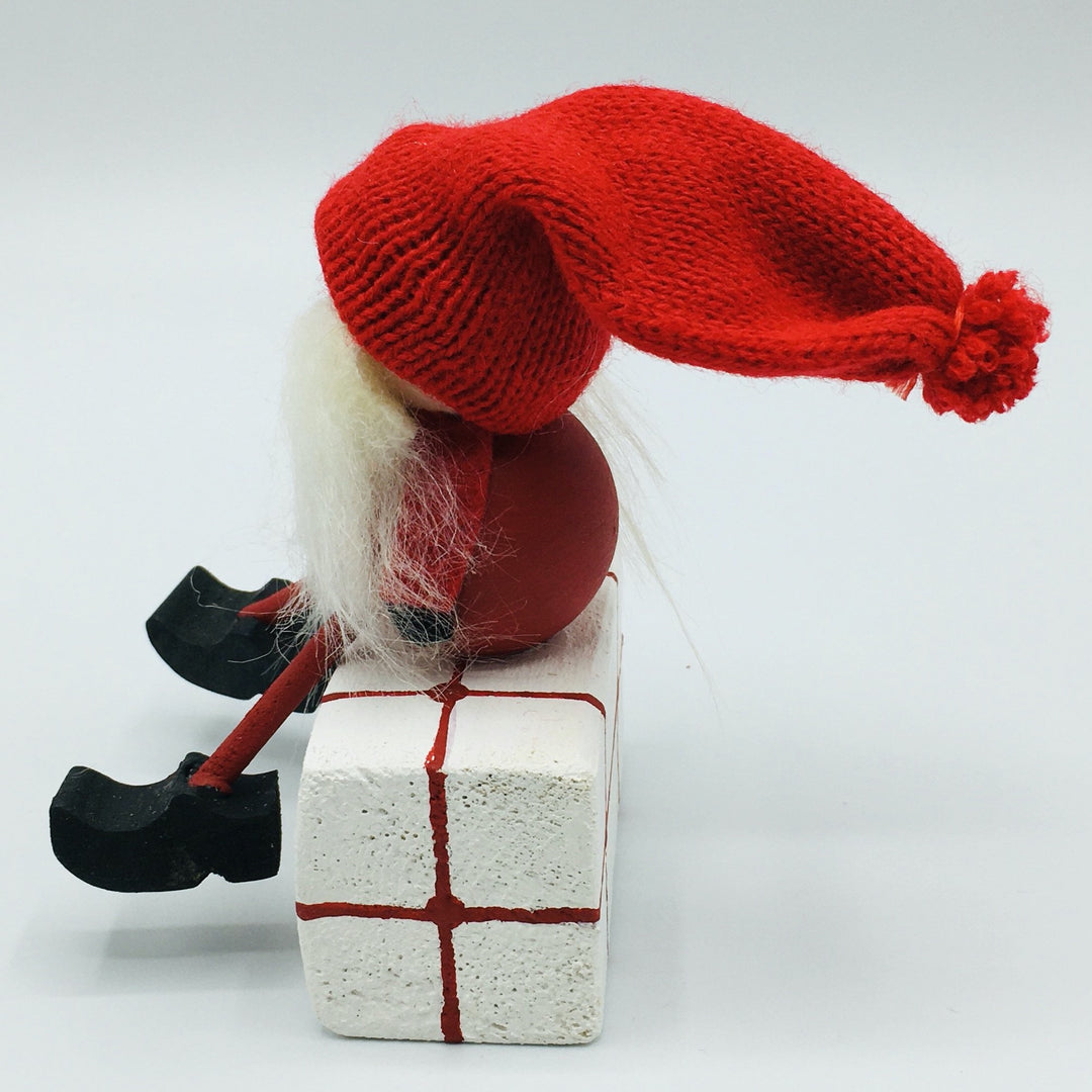 Hand made tomte sitting on gift