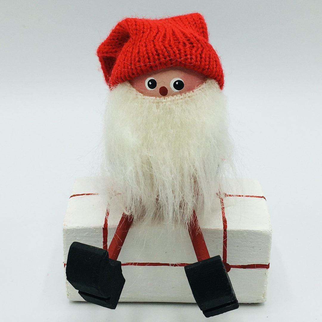 Hand made tomte sitting on gift